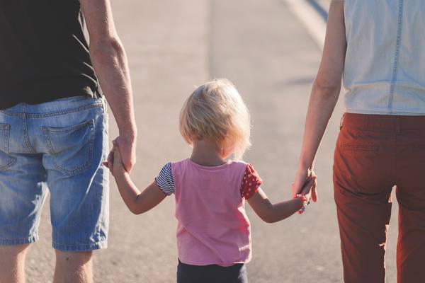 Eltern und Tochter gehen Hand in Hand